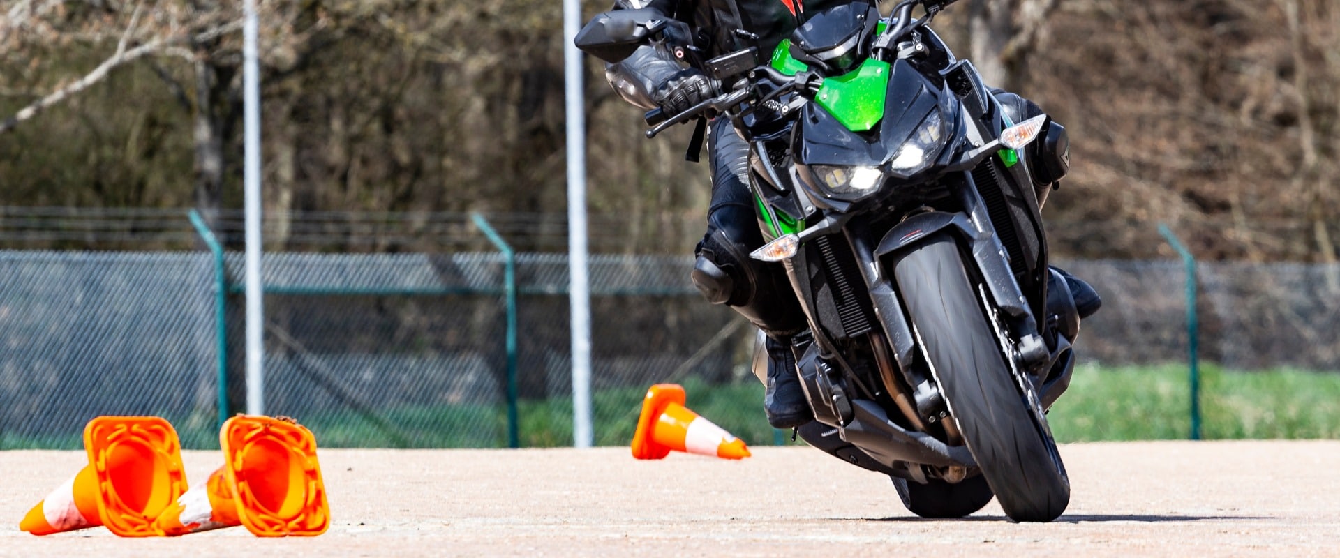 Motorradfahrer in Schräglage fährt Slalom bei Fahrsicherheitstraining zum Start der Motorrad Saison